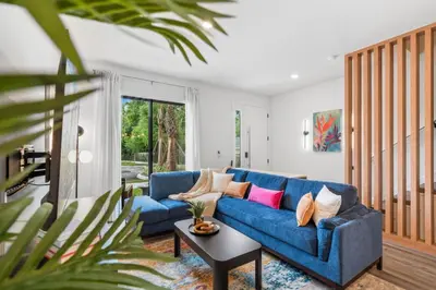 a living room with a blue couch and a table at Colorful vibrant Oasis Sleeps 10, 10min to Disney in Kissimmee