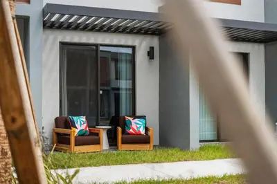 two chairs with colorful pillows sitting outside of a house at Colorful vibrant Oasis Sleeps 10, 10min to Disney in Kissimmee
