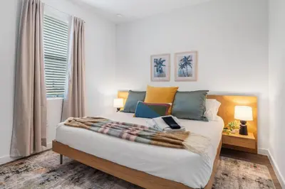 a bedroom with a large bed with a blanket on it at Colorful vibrant Oasis Sleeps 10, 10min to Disney in Kissimmee