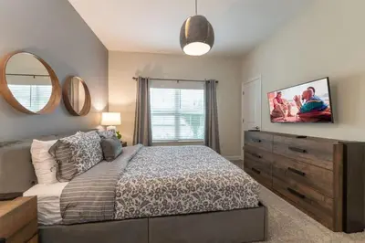 a bedroom with a bed with a dresser and a mirror at Casa 4Q com Piscina Privativa Próxima à Disney in Kissimmee