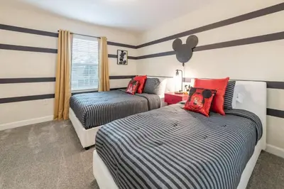 two beds in a room with striped walls at Casa 4Q com Piscina Privativa Próxima à Disney in Kissimmee