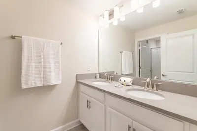 a white bathroom with two sinks and a mirror at Casa 4Q com Piscina Privativa Próxima à Disney in Kissimmee