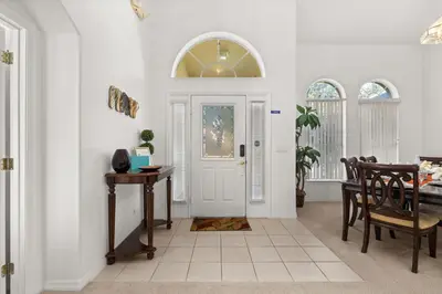 a dining room with a white door and a table at 373 - Stunning 4 Bedroom Villa with own Private South East Facing Pool in Orlando