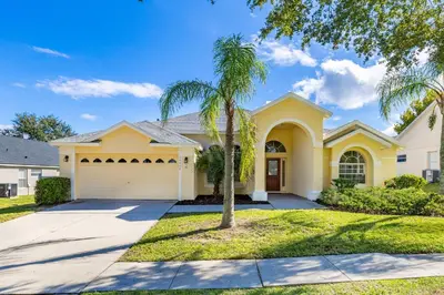 a palm tree in front of a house at 373 - Stunning 4 Bedroom Villa with own Private South East Facing Pool in Orlando
