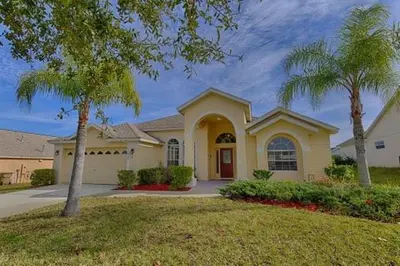 a house with a palm tree in front of it at 373 - Stunning 4 Bedroom Villa with own Private South East Facing Pool in Orlando