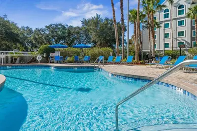 a swimming pool with chairs and umbrellas in a resort at Disney Potter Condo FREE Shuttle & Parking in Orlando