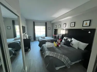 a bedroom with two beds and a mirror at Disney 1st floorEpicShuttle in Orlando