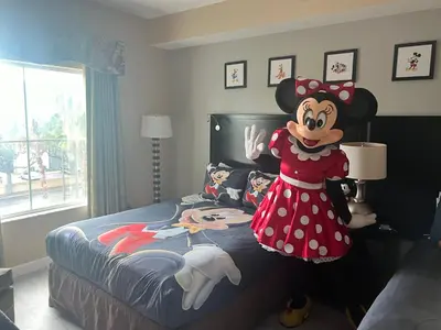 a room with a mickey mouse standing next to a bed at Disney 1st floorEpicShuttle in Orlando