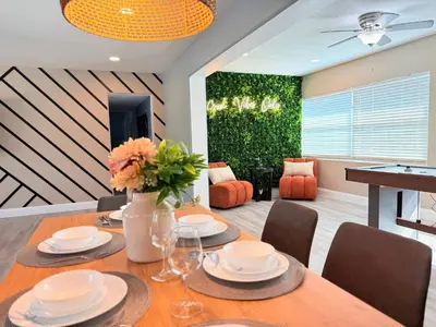 a dining room with a table with plates and flowers on it at Spacious Orlando Stay Free Wifi Game Room in Orlando