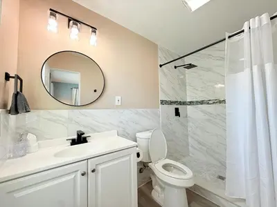 a bathroom with a sink and a toilet and a mirror at Spacious Orlando Stay Free Wifi Game Room in Orlando