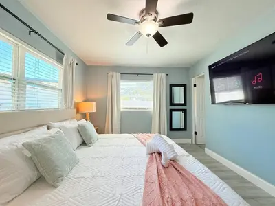 a bedroom with a large bed with a ceiling fan at Spacious Orlando Stay Free Wifi Game Room in Orlando