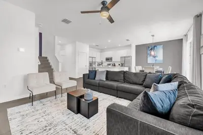 a living room with a couch and a table at Upstay Vibrant Home w Themed Rooms Pool & Games in Kissimmee