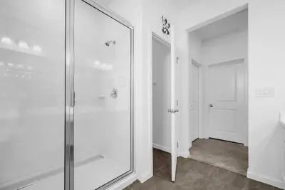 a glass shower in a bathroom with a hallway at Upstay Vibrant Home w Themed Rooms Pool & Games in Kissimmee