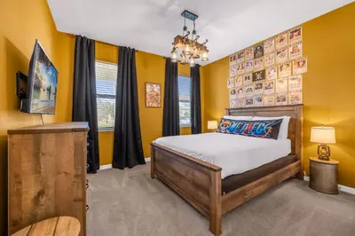 a bedroom with yellow walls and a bed and a chandelier at Upstay Vibrant Home w Themed Rooms Pool & Games in Kissimmee