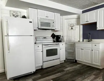 a kitchen with white cabinets and a white refrigerator at Welcome to Altamonte Springs! in Orlando