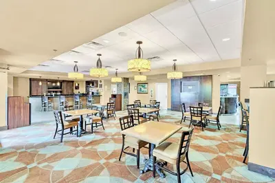a restaurant with tables and chairs and a bar at Peaceful King Bed Apartment w Hot Tub & Pool in Orlando