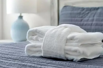a pile of white towels sitting on a bed at Relaxing Nature Escapade with Game Room in Orlando