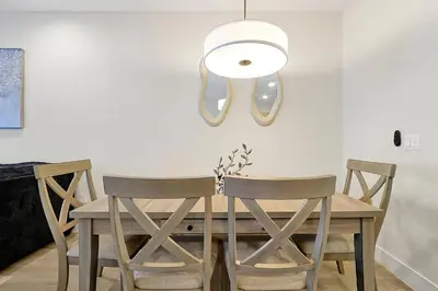 a dining room table with chairs and a light fixture at Relaxing Nature Escapade with Game Room in Orlando