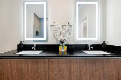 a bathroom with two sinks and two mirrors at Relaxing Nature Escapade with Game Room in Orlando