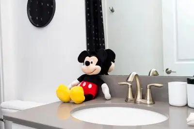 a mickey mouse toy sitting on a bathroom sink at Casa 5Q Storey Lake – Resort & Piscina in Kissimmee
