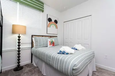 a bedroom with a bed and a lamp at Casa 5Q Storey Lake – Resort & Piscina in Kissimmee