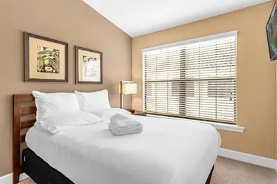 a bedroom with a large white bed with a window at Sunny Sales - Renovated TownHome by Disney! in Orlando