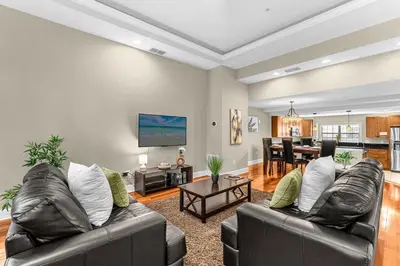 a living room with two leather couches and a table at Sunny Sales - Renovated TownHome by Disney! in Orlando