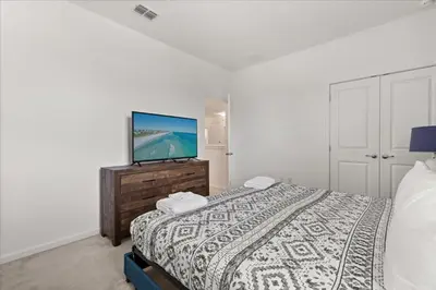 a bedroom with a bed and a flat screen tv at Summer Deal - Amazing 8BR Home with Private Pool! in Kissimmee