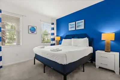 a blue bedroom with a bed and a blue wall at Summer Deal - Amazing 8BR Home with Private Pool! in Kissimmee