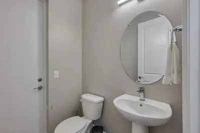 a bathroom with a toilet and a sink and a mirror at 7961 Luxuosa Villa de 4 Suítes com Piscina Privativa a 10 Minutos da Disney in Orlando