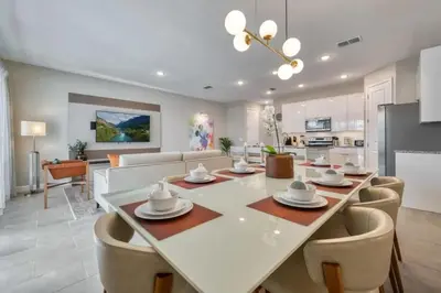 a dining room and living room with a table and chairs at 7961 Luxuosa Villa de 4 Suítes com Piscina Privativa a 10 Minutos da Disney in Orlando