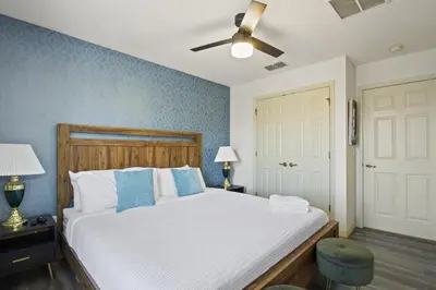 a bedroom with a large white bed with blue walls at Cozy 3bd Townhouse Near Disney Encantada Resort in Kissimmee