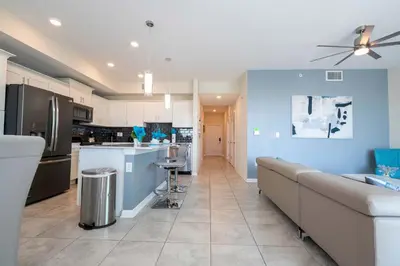 a kitchen with a couch and a kitchen with blue walls at Gorgeous 2Bd Close to Disney at Storey Lake Resort in Kissimmee