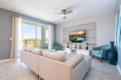 a living room with a white couch and chairs at Family Condo 2Bd Close to Disney at Storey Lake Resort in Kissimmee