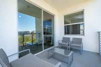 a balcony with a couch and chairs and a table at Family Condo 2Bd Close to Disney at Storey Lake Resort in Kissimmee