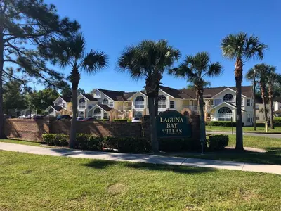 a sign in front of a yard with palm trees at Dream Superior 3BR Condo Near Disney Parks in Kissimmee