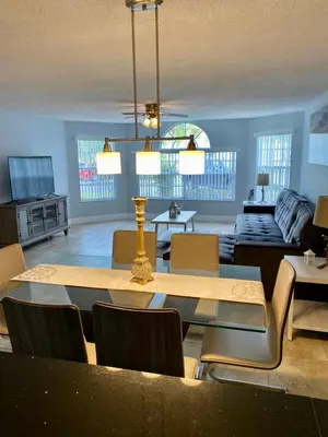 a living room with a table and chairs and a couch at Dream Superior 3BR Condo Near Disney Parks in Kissimmee