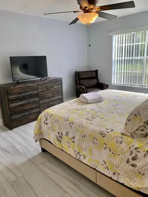 a bedroom with a bed and a flat screen tv at Dream Superior 3BR Condo Near Disney Parks in Kissimmee