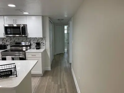 a kitchen with white cabinets and a counter top at Disney Superior 3BR Condo Near Theme Parks in Kissimmee