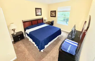 a bedroom with a bed and a television in it at King Room with Bathroom near Convention Center & Epic Universe in Orlando
