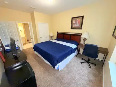 a bedroom with a bed and a desk and a desk at King Room with Bathroom near Convention Center & Epic Universe in Orlando