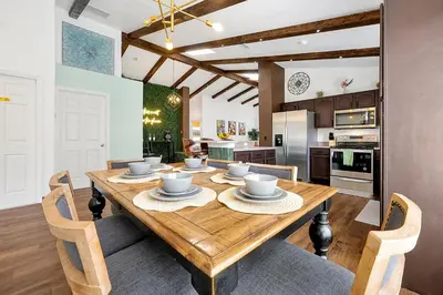 a kitchen and dining room with a wooden table and chairs at 5BR Cottage w Pool & Hot Tub Near Disney in Kissimmee