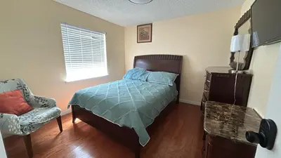 a bedroom with a bed and a chair and a window at Orlando Family 4BR | 10 Min to SeaWorld in Orlando