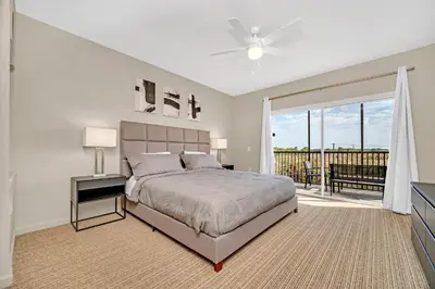 a bedroom with a large bed and a balcony at Modern Pet-Friendly - 2BR Condo - 6 mins from Disney in Orlando