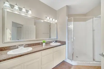a bathroom with two sinks and a shower at Modern Pet-Friendly - 2BR Condo - 6 mins from Disney in Orlando