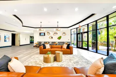 an open living room with leather furniture and large windows at Condo with Pet-Friendly- Sauna & Pool in Orlando