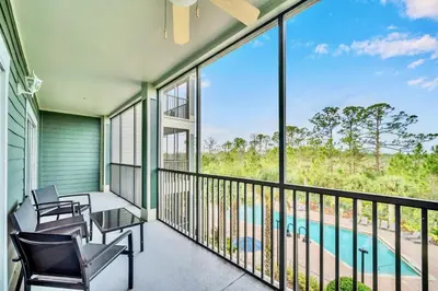 a balcony with chairs and a view of a pool at Stylish 2BR Retreat w Pool Sauna in Orlando