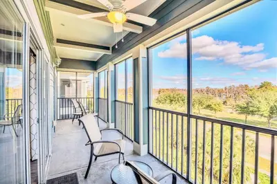 a screened porch with chairs and a ceiling fan at Pet-Friendly Condo -Upstay Near Disney w Pool in Orlando