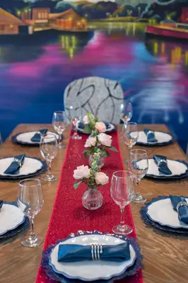a table with plates and glasses and a red table cloth at Fabulous Condo at World Quest Resort Disney area in Orlando