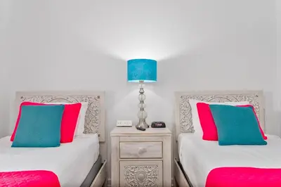 two beds with pink and blue pillows in a room at Fabulous Condo at World Quest Resort Disney area in Orlando
